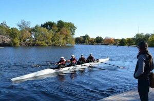 coach watches as team practices rowing
