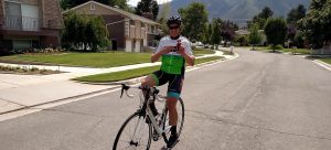 Scott Mathers holding HOTSHOT bottle on bike
