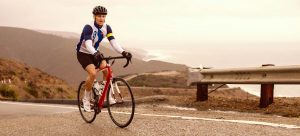 athlete on bike near edge of road