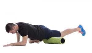 male athlete using foam roller