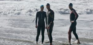 three athletes waiting by the water