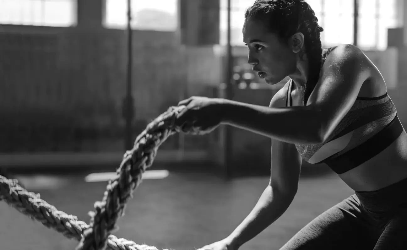 woman in gym working out with ropes