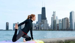 woman stretching on blanket by river