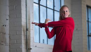 athlete in red jacket stretching