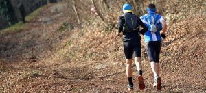 two athletes running on trail