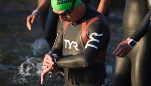 athlete in water checking watch before race