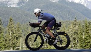 athlete riding bike on road in mountains