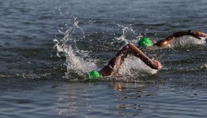 two swimmers with green caps