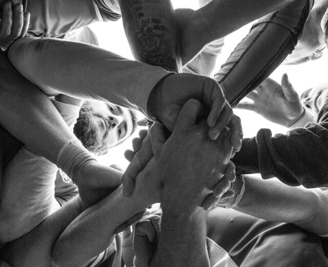 athletes grasping hands to show teamwork